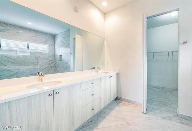 5048 Gambero Way, Ave Maria, FL 34142 - bathroom featuring a sink, a walk in closet, baseboards, and double vanity