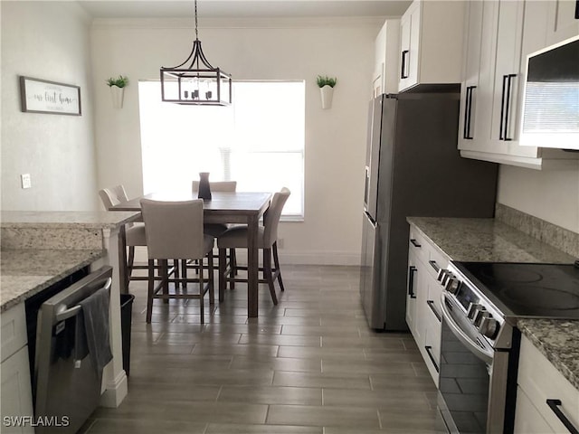 2939 Orange Grove Trl, Naples, FL 34120 - kitchen featuring stainless steel appliances, wood finished floors, white cabinetry, light stone counters, and crown molding