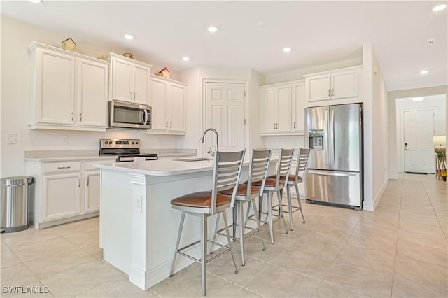 2916 Royal Gardens Ave, Fort Myers, FL 33916 - kitchen with appliances with stainless steel finishes, an island with sink, a sink, and white cabinetry