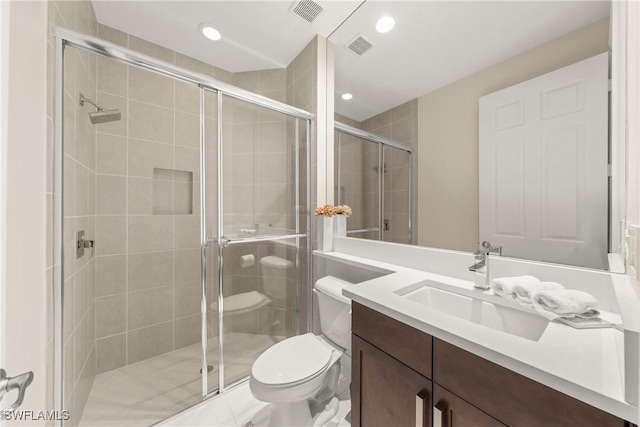 full bathroom featuring a stall shower, visible vents, toilet, and vanity
