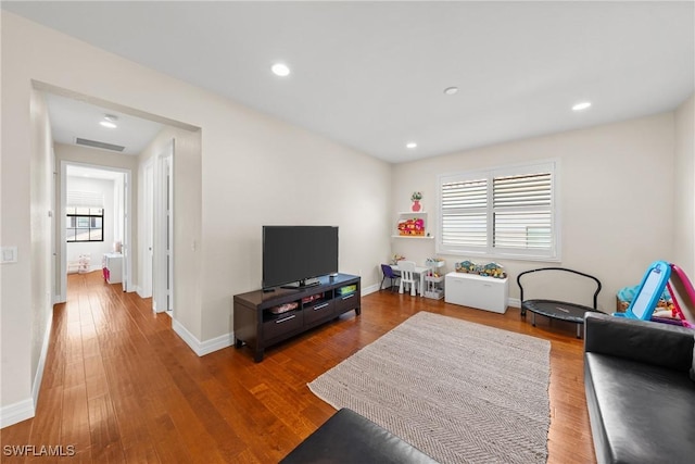living area featuring baseboards, visible vents, wood finished floors, and recessed lighting