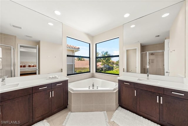 ensuite bathroom featuring a stall shower, tile patterned floors, a sink, and a garden tub
