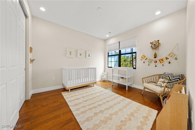 bedroom featuring baseboards, wood finished floors, and recessed lighting