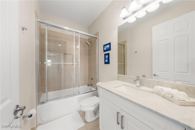 full bath with tile patterned floors, bath / shower combo with glass door, toilet, and vanity