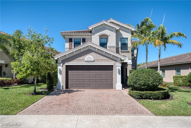 view of front facade with decorative driveway, stucco siding, an attached garage, and a front lawn