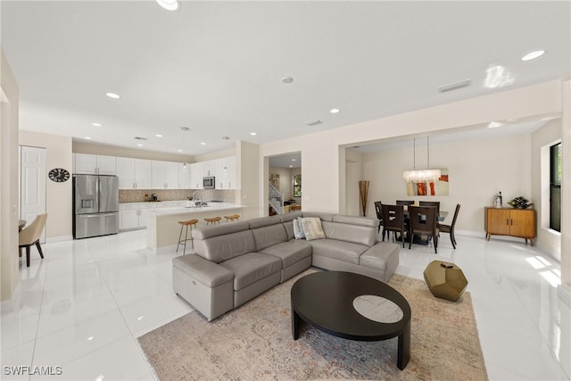 living room with visible vents, light tile patterned floors, recessed lighting, and a chandelier