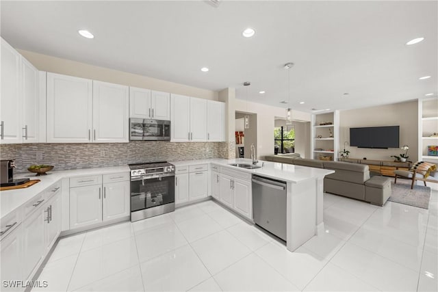 kitchen featuring light countertops, a sink, stainless steel appliances, and a peninsula