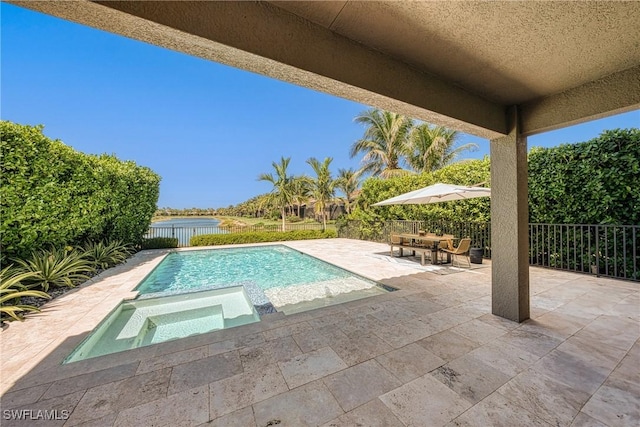 view of pool with a fenced backyard, a pool with connected hot tub, a water view, and a patio area