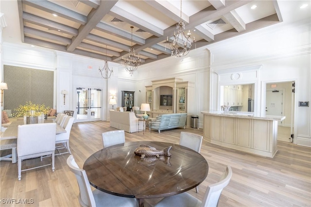 dining area featuring visible vents, light wood finished floors, a towering ceiling, french doors, and a notable chandelier