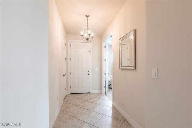 10870 Maitland Way, Fort Myers, FL 33913 - hallway with a chandelier, light tile patterned floors, and baseboards