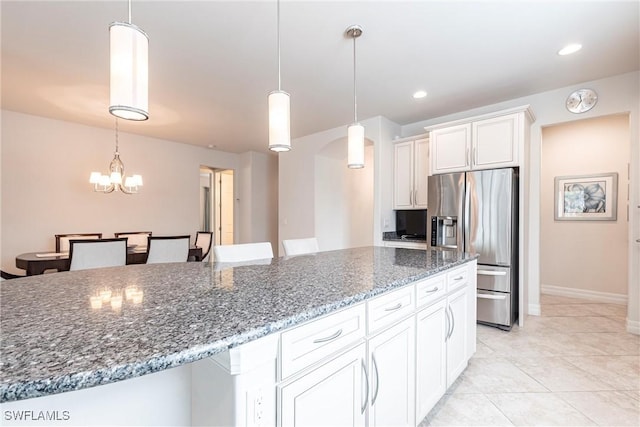 10870 Maitland Way, Fort Myers, FL 33913 - kitchen featuring stainless steel refrigerator with ice dispenser, white cabinets, dark stone countertops, pendant lighting, and a chandelier