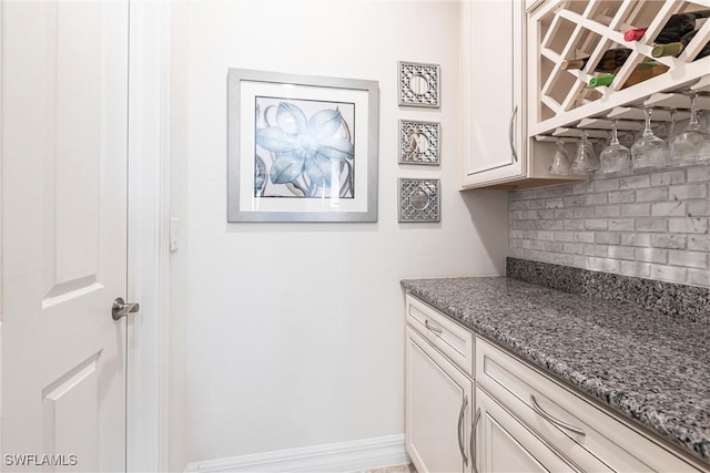 10870 Maitland Way, Fort Myers, FL 33913 - kitchen with tasteful backsplash, stone countertops, white cabinetry, and baseboards