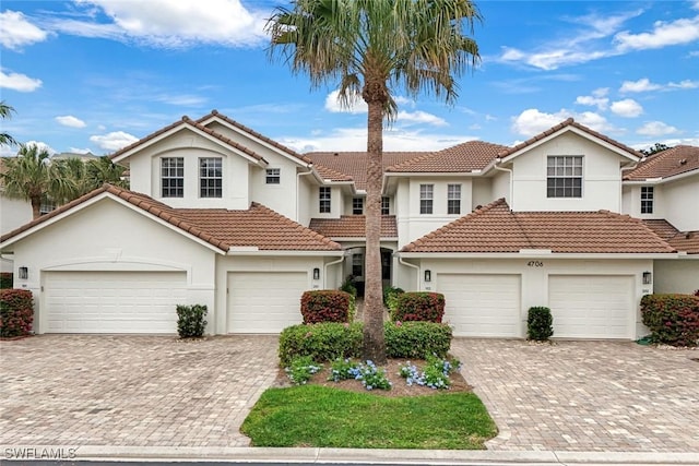 4706 Montego Pointe Way Unit 201, Bonita Springs, FL 34134 - view of front of property with decorative driveway, stucco siding, a tiled roof, and a garage