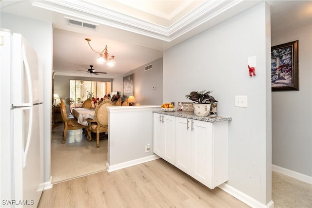 402 SE 42nd Ter Unit D 5, Cape Coral, FL 33904 - kitchen featuring freestanding refrigerator, light wood finished floors, white cabinetry, visible vents, and ornamental molding