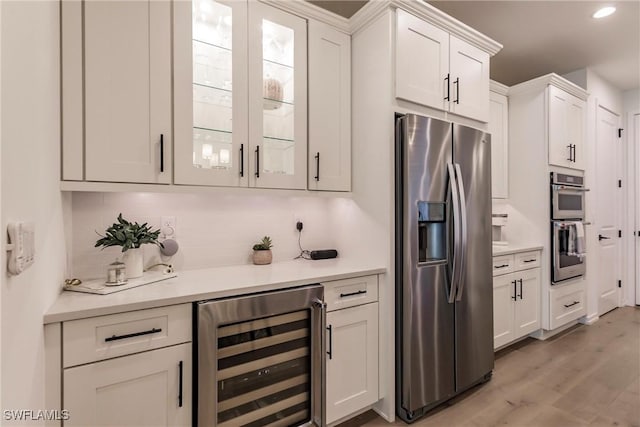 13005 Pembroke Dr, Naples, FL 34105 - kitchen with light countertops, stainless steel appliances, backsplash, and beverage cooler