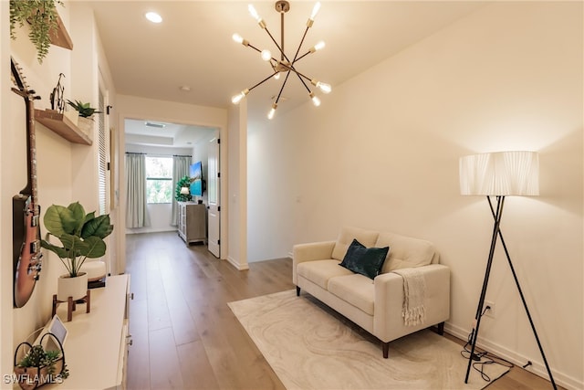 13005 Pembroke Dr, Naples, FL 34105 - living area with light wood finished floors and a notable chandelier