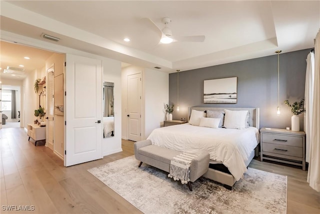 13005 Pembroke Dr, Naples, FL 34105 - bedroom featuring light wood-style flooring, a tray ceiling, and visible vents