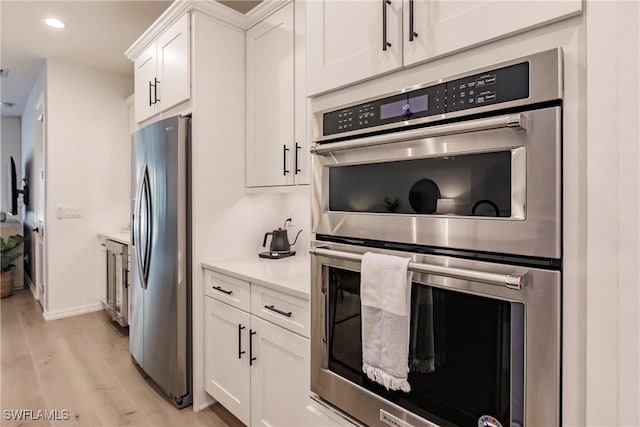 13005 Pembroke Dr, Naples, FL 34105 - kitchen with light countertops, recessed lighting, appliances with stainless steel finishes, white cabinetry, and light wood-style floors