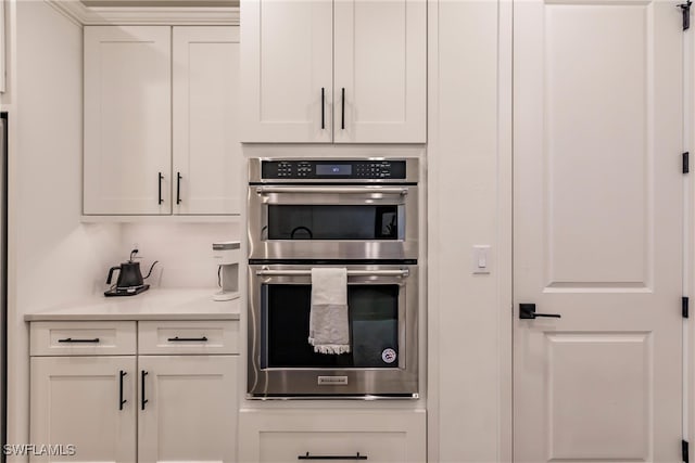 13005 Pembroke Dr, Naples, FL 34105 - kitchen with white cabinets, light countertops, and stainless steel double oven