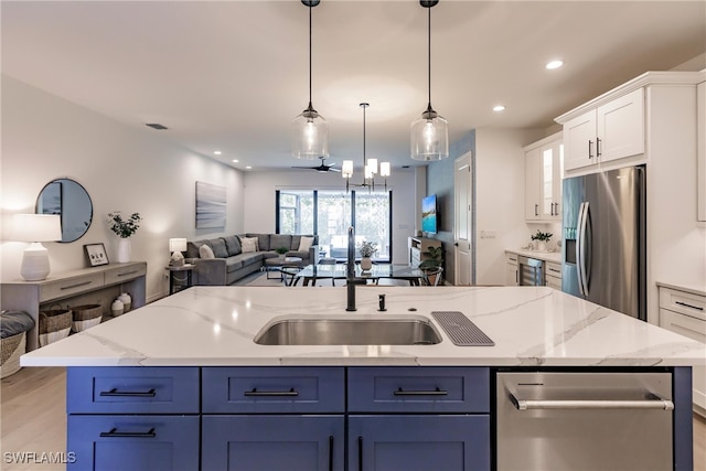 13005 Pembroke Dr, Naples, FL 34105 - kitchen featuring white cabinets, a center island with sink, a sink, stainless steel refrigerator with ice dispenser, and open floor plan