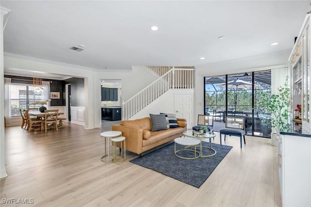 living area with visible vents, crown molding, recessed lighting, stairway, and light wood-style floors