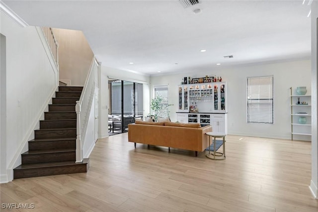 living room with stairway, light wood-type flooring, visible vents, a dry bar, and recessed lighting
