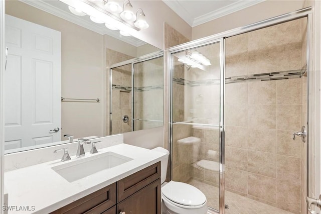 full bath featuring a shower stall, toilet, vanity, and ornamental molding