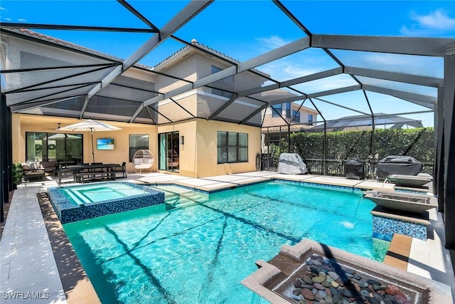 view of pool with a pool with connected hot tub, glass enclosure, and a patio area