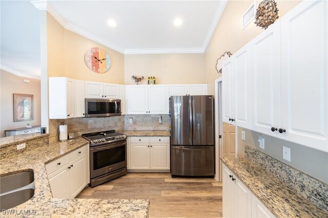 931 SW 35th Ter, Cape Coral, FL 33914 - kitchen featuring light wood finished floors, white cabinetry, tasteful backsplash, appliances with stainless steel finishes, and ornamental molding