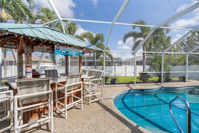 931 SW 35th Ter, Cape Coral, FL 33914 - view of pool with outdoor dry bar, a patio, a fenced backyard, a fenced in pool, and glass enclosure