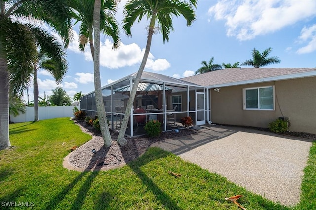 931 SW 35th Ter, Cape Coral, FL 33914 - back of house featuring a lanai, stucco siding, fence, a lawn, and a patio area