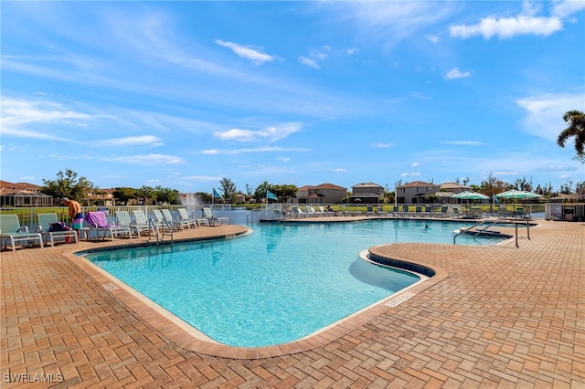 community pool featuring fence and a patio area