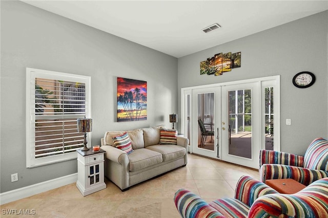 living area featuring french doors, light tile patterned floors, baseboards, and visible vents