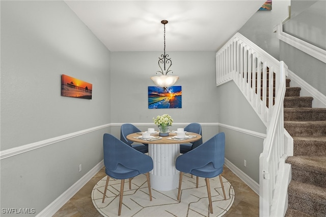 dining space with baseboards and stairway