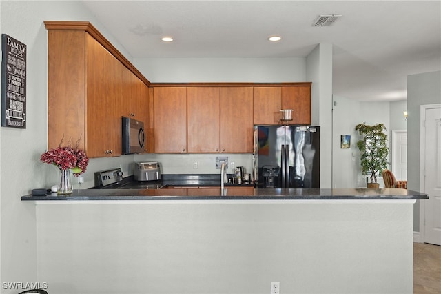 kitchen featuring visible vents, a peninsula, brown cabinets, dark countertops, and black appliances