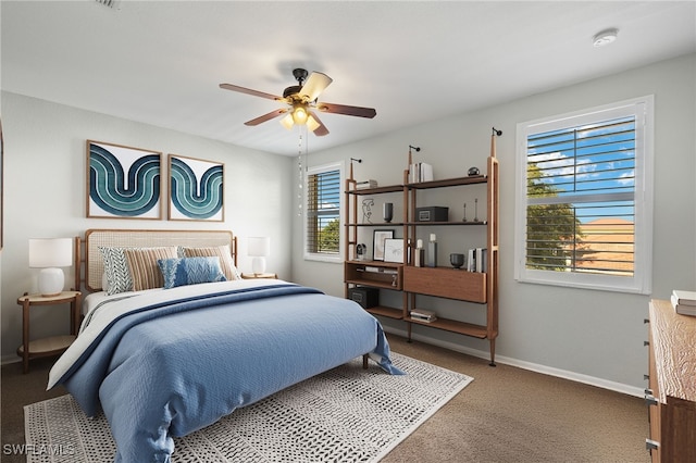carpeted bedroom featuring baseboards and ceiling fan