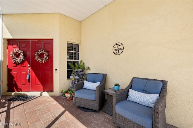 entrance to property with stucco siding and a patio