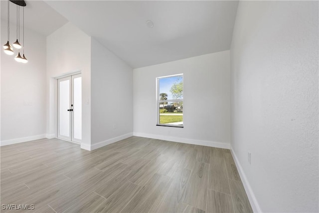 bonus room featuring baseboards, lofted ceiling, and light wood-style floors