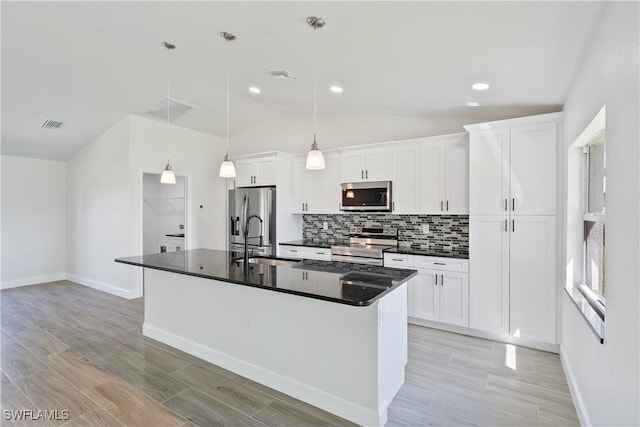 kitchen featuring stainless steel appliances, dark countertops, a sink, vaulted ceiling, and backsplash