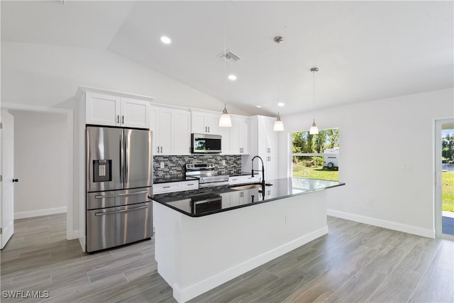 kitchen featuring a sink, stainless steel appliances, visible vents, white cabinets, and decorative backsplash
