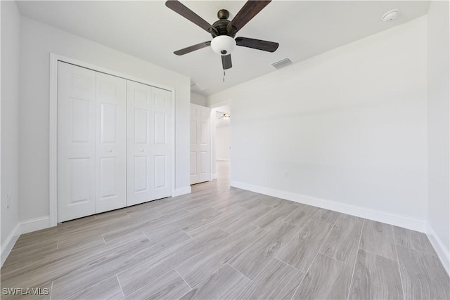 unfurnished bedroom with baseboards, visible vents, a closet, and light wood-style floors