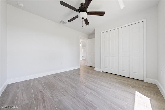 unfurnished bedroom with baseboards, light wood finished floors, visible vents, a ceiling fan, and a closet