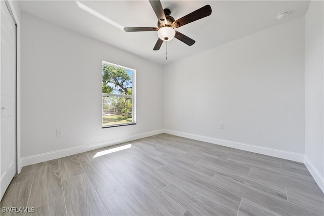 empty room with baseboards, light wood-style flooring, and a ceiling fan
