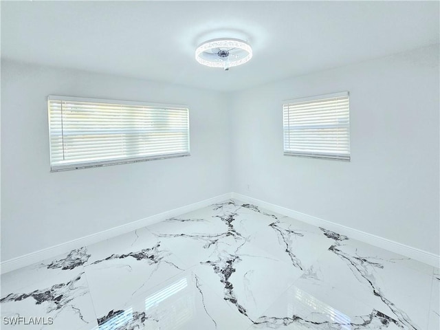 1312 Archdale St, Lehigh Acres, FL 33936 - spare room featuring baseboards and light marble finish floors