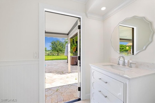 entryway featuring ornamental molding, a sink, recessed lighting, and wainscoting