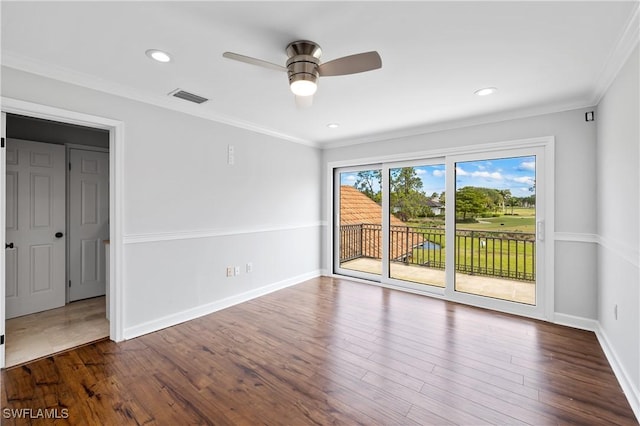 empty room with visible vents, wood finished floors, and ornamental molding