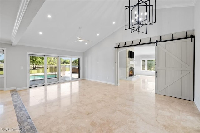unfurnished living room featuring a barn door, high vaulted ceiling, a healthy amount of sunlight, and ceiling fan with notable chandelier