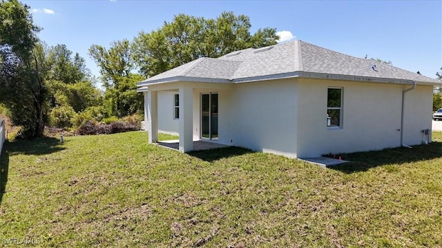 1508 Hibiscus Ave, Lehigh Acres, FL 33972 - rear view of house with stucco siding, a shingled roof, and a yard
