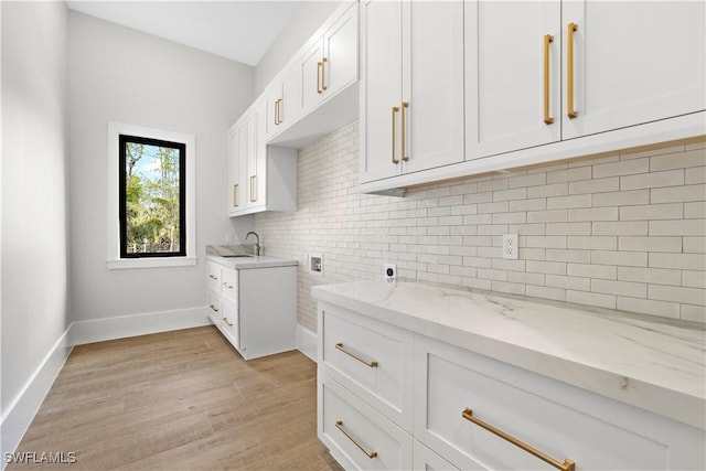 4987 Mahogany Ridge Dr, Naples, FL 34119 - laundry area featuring light wood finished floors, a sink, cabinet space, hookup for a washing machine, and baseboards