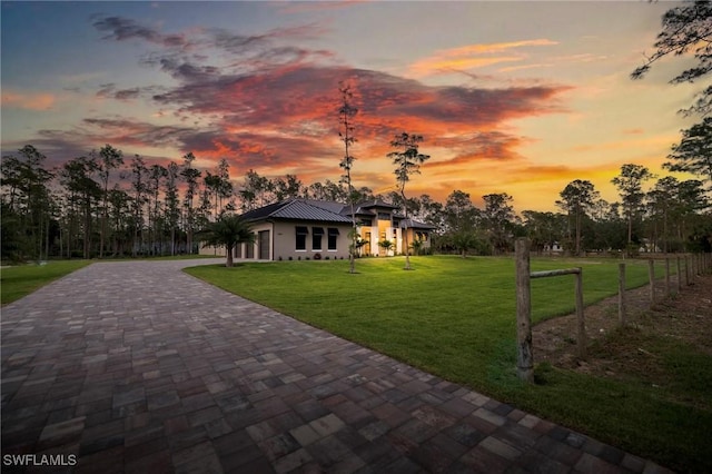4987 Mahogany Ridge Dr, Naples, FL 34119 - view of front of house with decorative driveway, metal roof, and a front yard